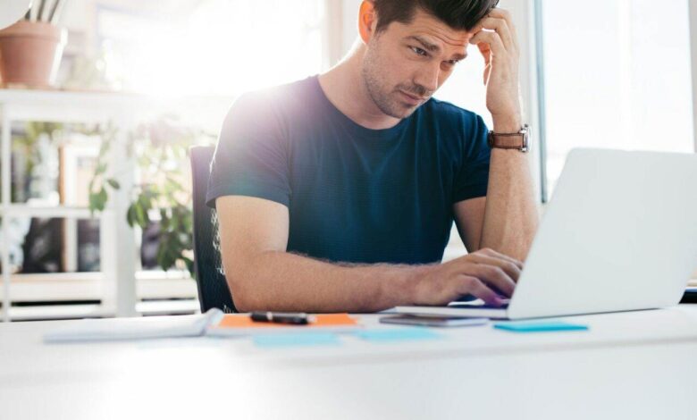 Young man using laptop and looking worried