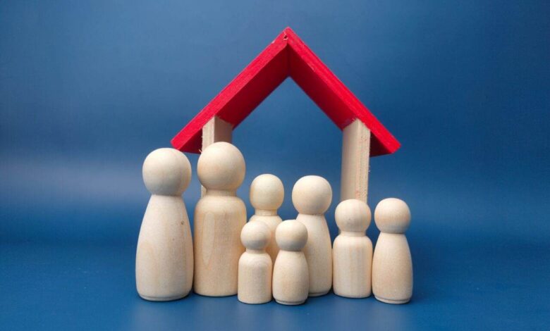 A family wooden doll with wooden house on a blue background.